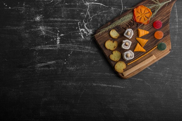 Croustilles avec des produits de pâtisserie sur un plateau en bois dans le coin supérieur