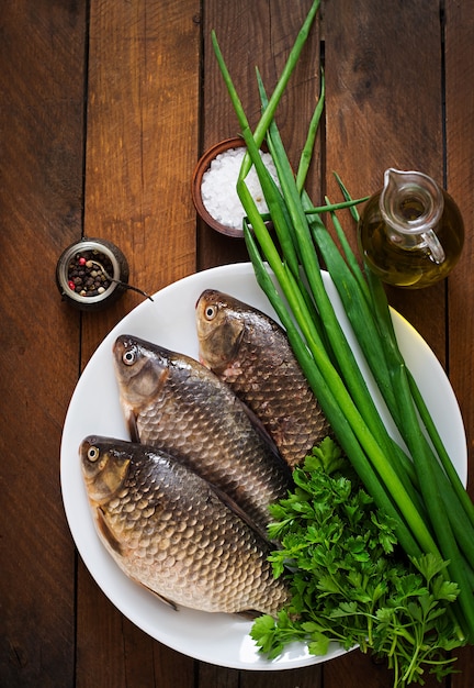 Crucian cru frais sur un bois aux herbes