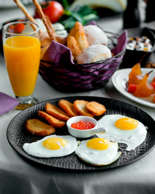 Crutones frits avec oeufs au plat et orange fraîche