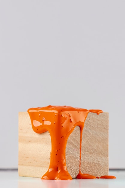 Cube en bois avec gouttes de peinture orange