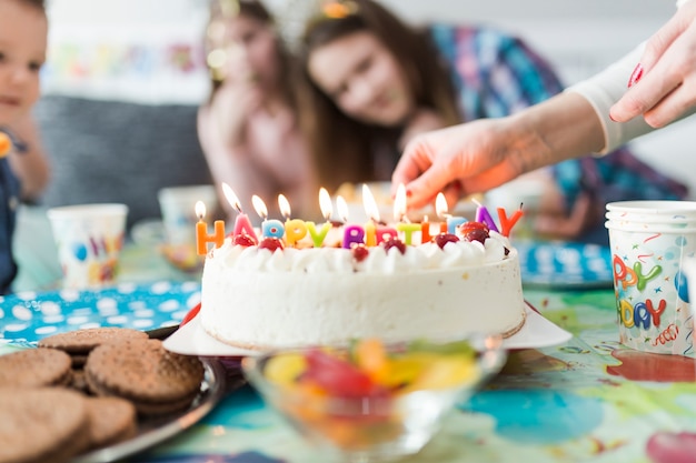 Cueillir les mains près de gâteau avec des bougies