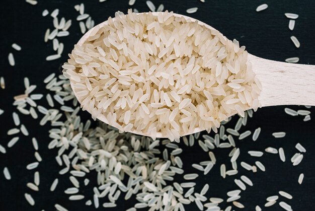 Cuillère en bois avec du riz non cuit