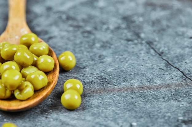 Photo gratuite une cuillère en bois de pois verts bouillis.