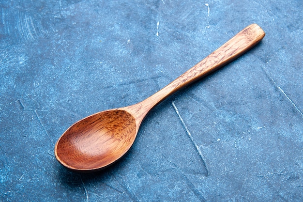 Cuillère en bois vue de dessous sur table bleue