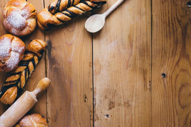 Cuillère et rouleau à pâtisserie près de petits pains