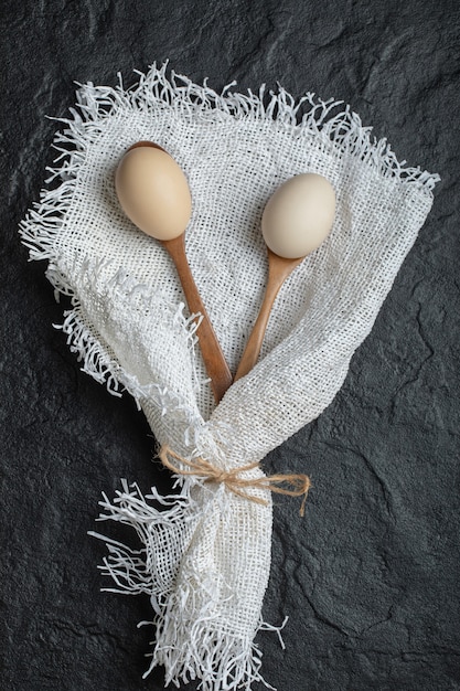 Cuillères en bois d'œufs de poule sur toile de jute