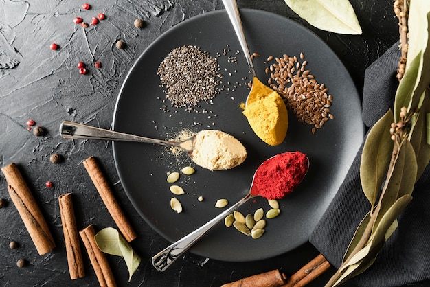 Photo gratuite cuillères avec diverses poudres de condiments en plaque