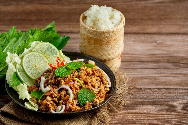Cuisine thaïlandaise avec du porc haché épicé servi avec des plats d'accompagnement et du riz gluant