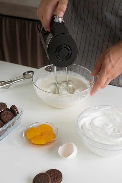 Photo gratuite cuisinier à angle élevé faisant de la crème