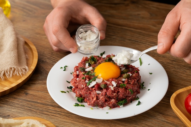 Cuisinier à angle élevé préparant un tartare de steak de boeuf