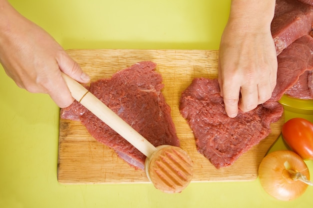 cuisinier les mains faisant du steak tendre