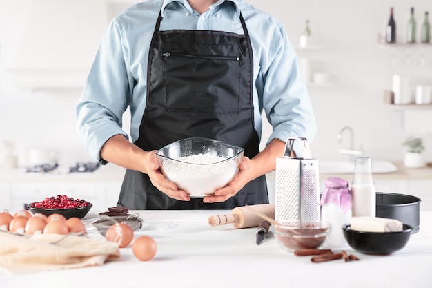 Un cuisinier avec des œufs sur une cuisine rustique contre les mains des hommes