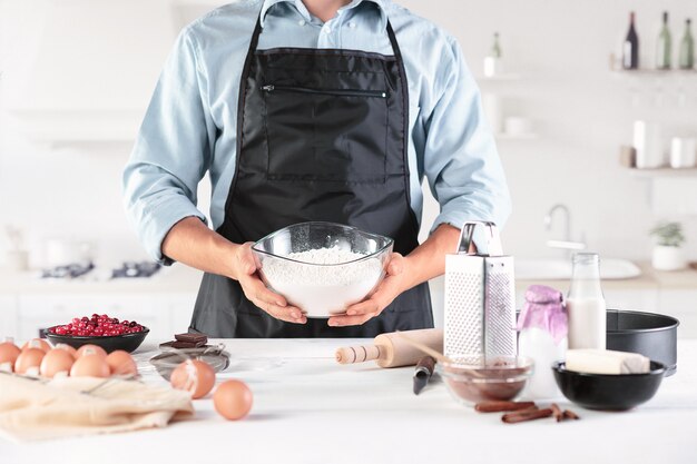 Un cuisinier avec des œufs sur une cuisine rustique contre les mains des hommes