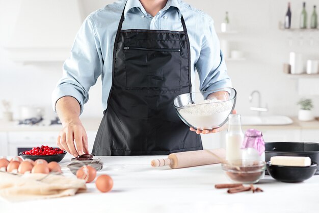 Un cuisinier avec des œufs sur une cuisine rustique contre le mur des mains des hommes