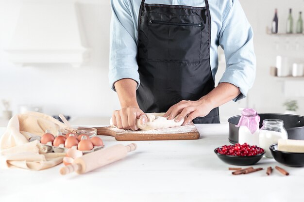 Un cuisinier avec des œufs sur une cuisine rustique contre le mur des mains des hommes