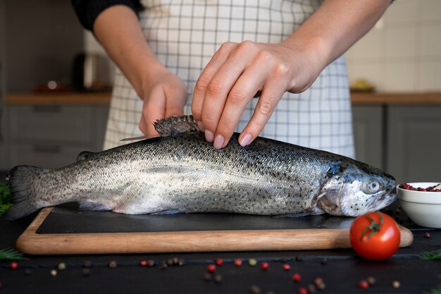 Photo gratuite cuisinier vue de face nettoyant le poisson dans la cuisine