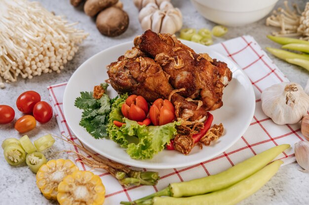 Cuisse de poulet frit avec tomate, chili, oignon frit, laitue, maïs et champignon aiguille.