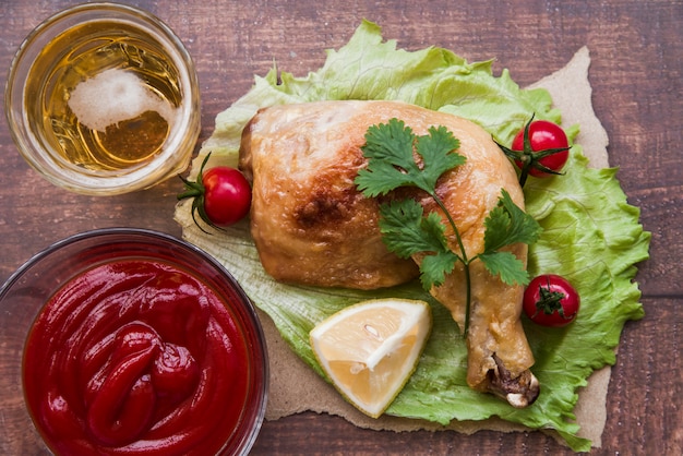 Cuisse de poulet grillé garnie de sauce; bière et tomates cerises