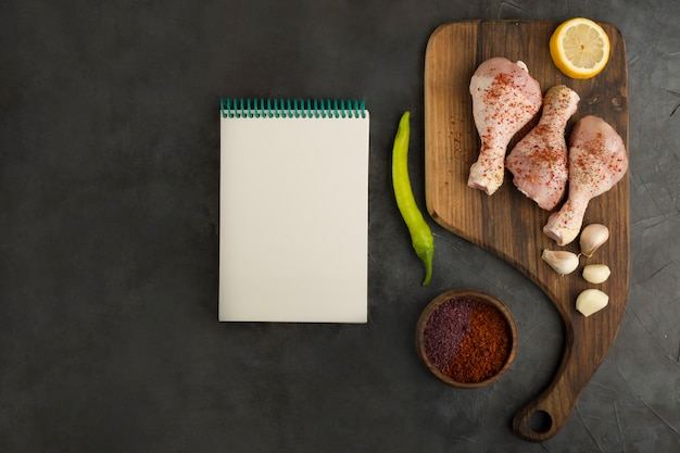 Cuisses de poulet crues avec un livre de reçus de côté