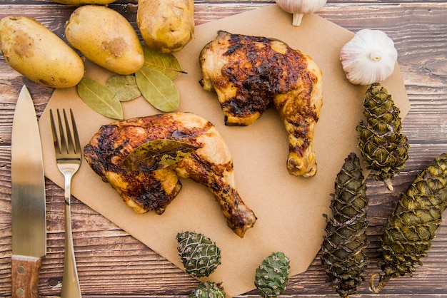 Photo gratuite cuisses de poulet cuites au four sur une table en bois