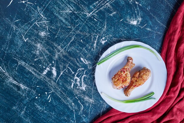 Cuisses de poulet épicées frites dans une assiette blanche.