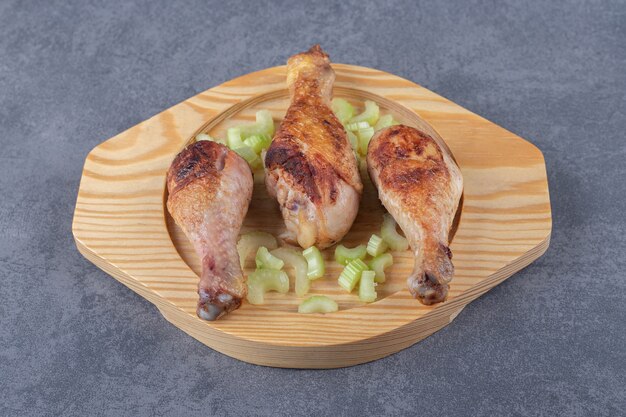 Cuisses de poulet frites sur plaque de bois.