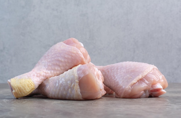 Cuisses de poulet non cuites sur fond de marbre. photo de haute qualité