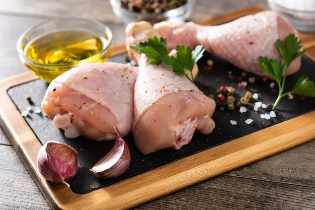 Cuisses de viande de poulet crues sur table en bois