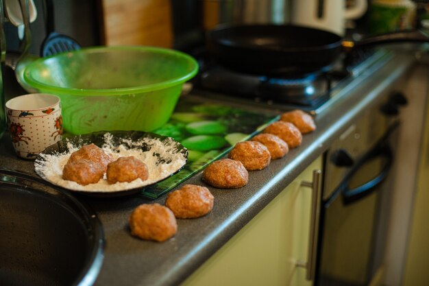 Photo gratuite cuisson des boulettes de viande, du hachis prêt à rôtir sur la table de la cuisine