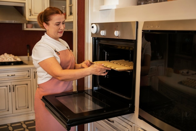Photo gratuite cuisson confiseur femelle avec de la pâte dans une pâtisserie