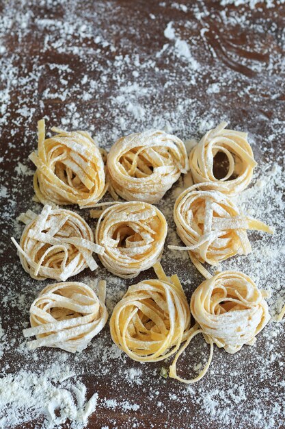 Cuisson des pâtes italiennes maison sur fond sombre