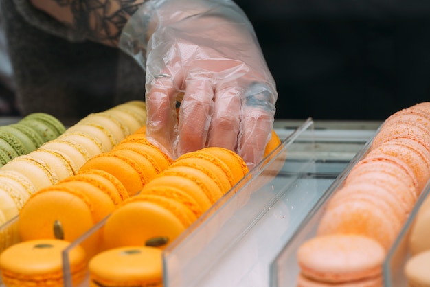 Culture de la main prenant des macarons jaunes