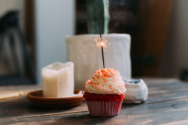 Cupcake d'anniversaire rose avec bougie scintillante