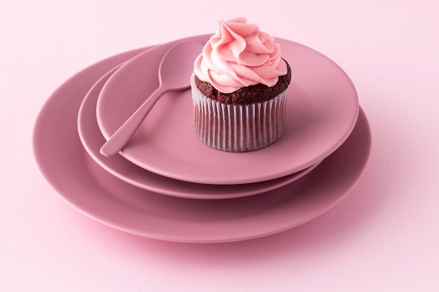 Cupcake et cuillère à angle élevé sur des assiettes