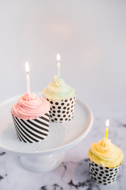 Photo gratuite cupcakes sur l'affichage avec des bougies