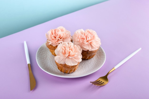 Cupcakes à angle élevé avec des fleurs sur fond violet