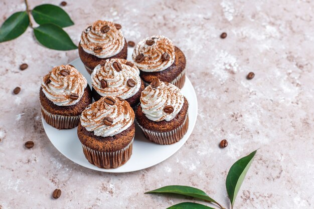 Cupcakes au café décorés de crème fouettée et de grains de café.