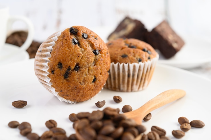 Photo gratuit cupcakes aux bananes mélangés avec des pépites de chocolat sur une plaque blanche.