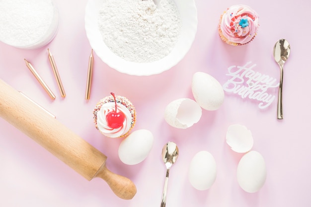 Cupcakes près d&#39;ingrédients de gâteau d&#39;anniversaire