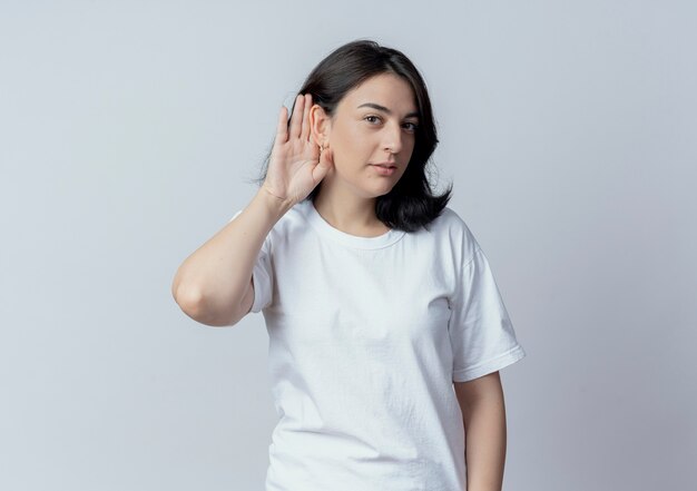 Curieux jeune fille assez caucasienne faisant ne peut pas vous entendre geste à la caméra isolé sur fond blanc avec copie espace