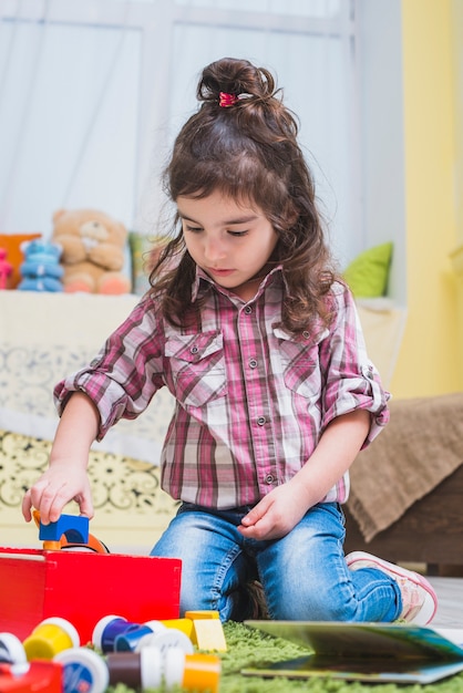 Curly girl jouant avec des jouets