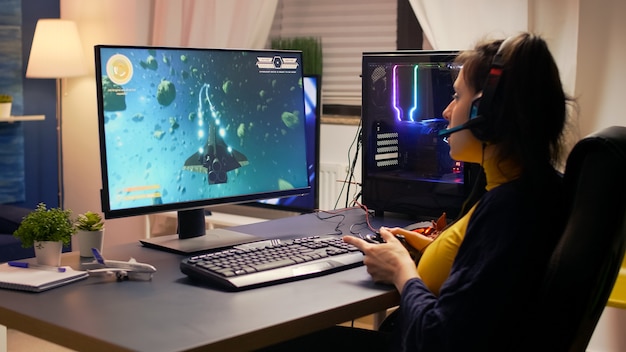 Cyber gamer compétitif remportant un tournoi de jeux vidéo en ligne portant un casque professionnel