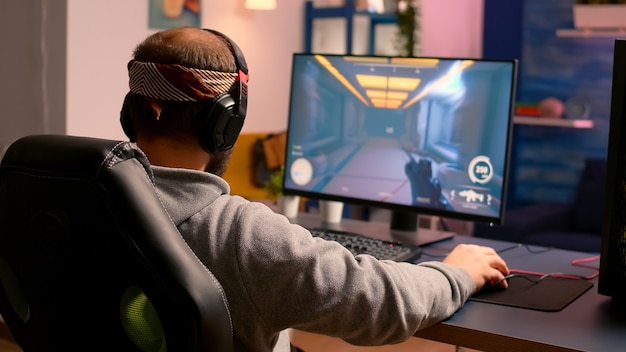 Cyber gamer s'étirant les mains et le cou avant de jouer à des jeux vidéo en ligne à l'aide d'un clavier et d'une souris RVB. Joueur exécutant des jeux en ligne pendant le tournoi de jeu