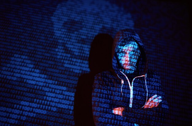 Cyberattaque avec un pirate informatique à capuche méconnaissable utilisant la réalité virtuelle, effet de pépin numérique