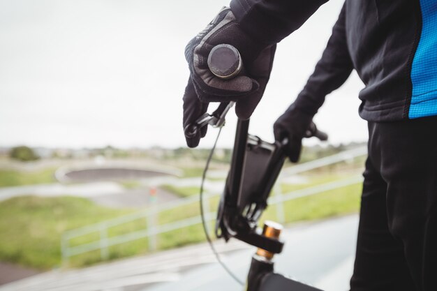 Cycliste debout avec vélo BMX sur la rampe de départ