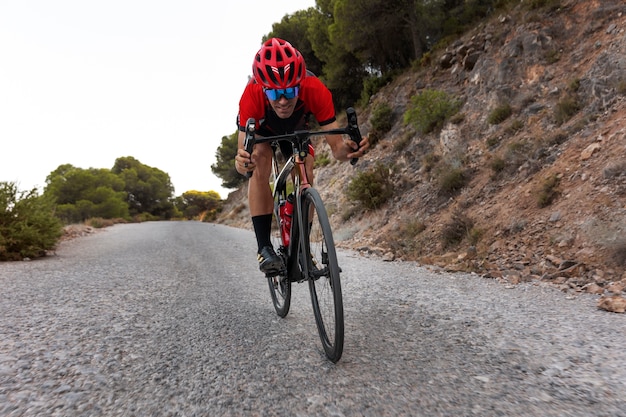 Photo gratuite cycliste masculin avec formation de casque sur le vélo à l'extérieur