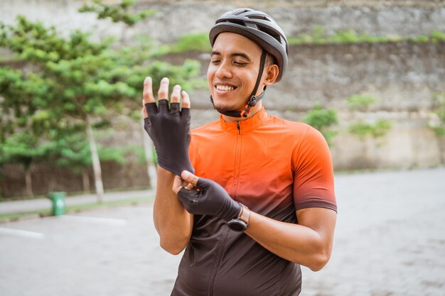 Cycliste en vêtements de sport et casque de protection faisant du vélo noir dans la campagne le matin