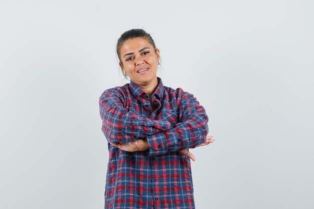 Photo gratuite dame debout avec les bras croisés en chemise décontractée et à la vue de face, confiant.