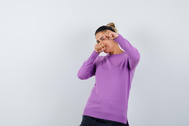 Dame debout dans la pose de combat en blouse de laine et à la puissante