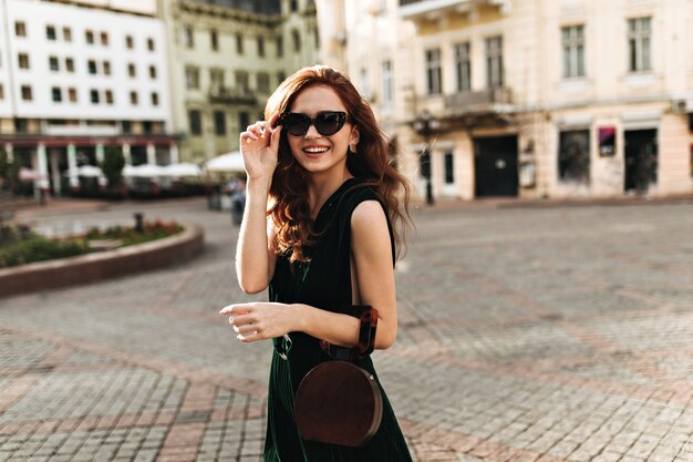 Dame élégante à lunettes de soleil se promenant dans la ville